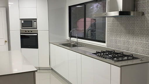 Cocina blanca con lavaplatos y encimera separados · Construmuebles